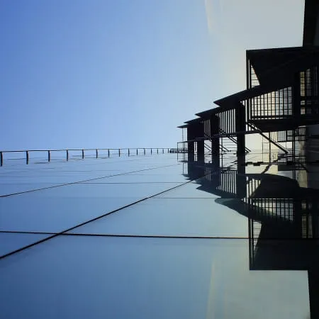 Reflektierendes Glasgebäude mit klarem blauen Himmel
